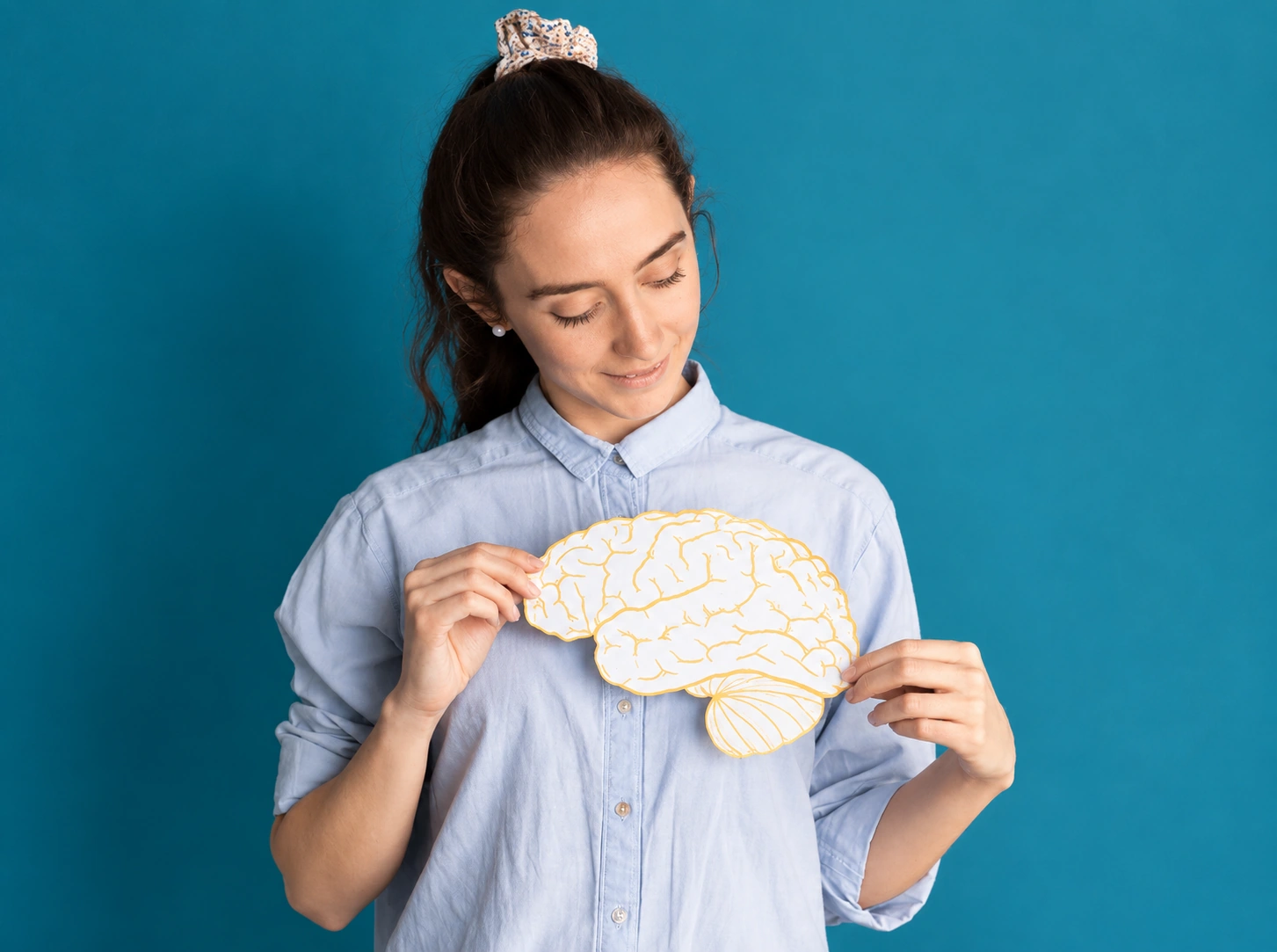 A woman holding a model of the brain